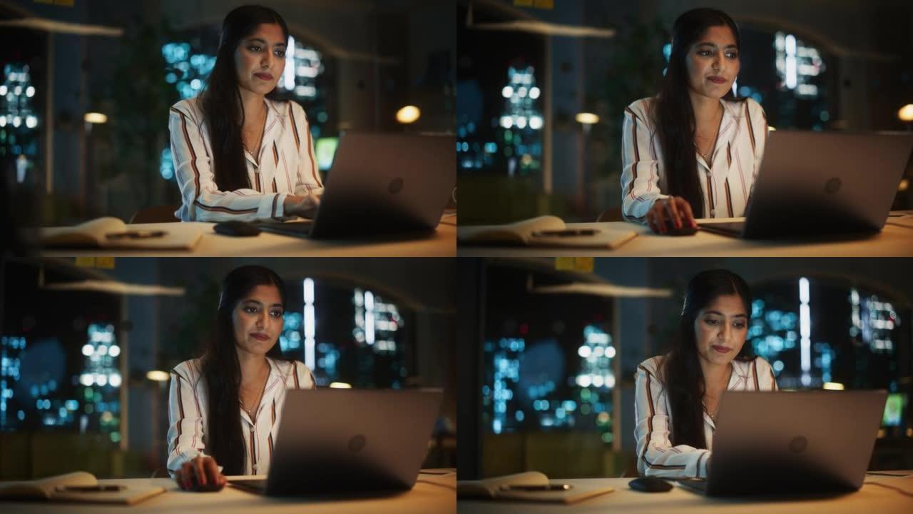 晚上在公司办公室里，一位美丽的印度女性在笔记本电脑上工作的肖像。年轻的秘书分析报告。客户经理为客户制