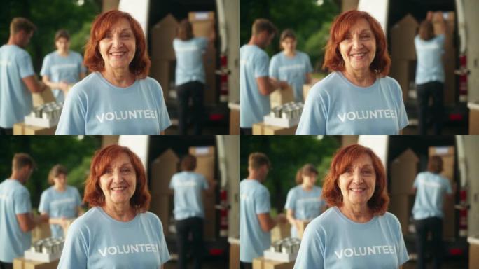 一位快乐乐于助人的中年女志愿者的肖像。成年白人妇女穿着蓝色t恤，微笑着看着相机。人道主义援助、捐赠中
