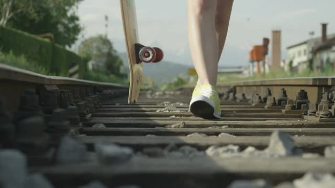 慢动作特写: 年轻女子在铁路上行走