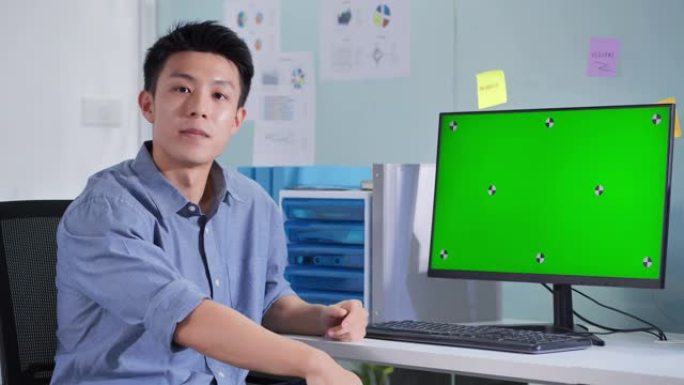 领导亚洲商人在会议遥控器上在绿屏计算机上展示。绿屏