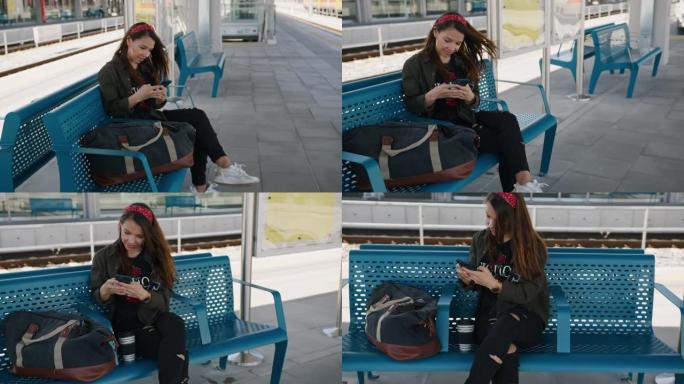 女人坐在火车站的长凳上使用手机