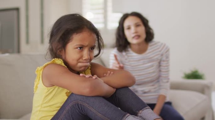 愤怒的西班牙裔母亲告诉她年轻的updet女儿坐在沙发上