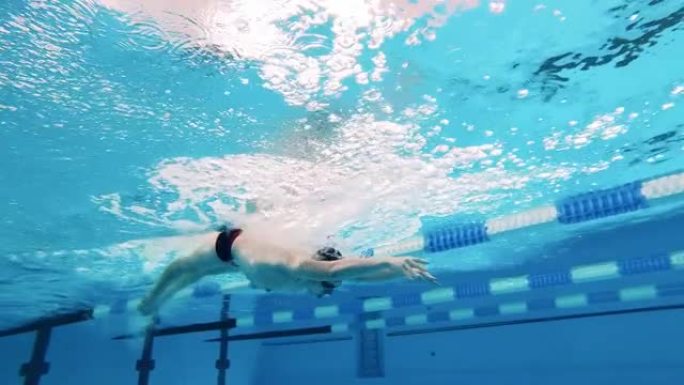 运动员训练在水下游泳。水下射击，运动活动的概念，决心，锻炼，健康的生活方式。