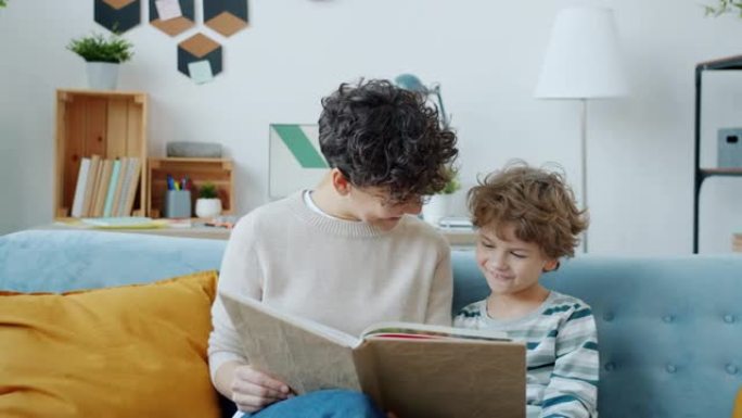 年轻的母亲读有趣的书给可爱的男孩在家教育孩子