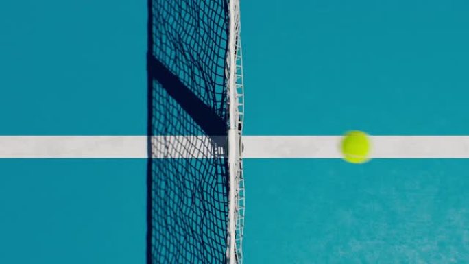 网球场鸟瞰图玩游戏。摄像机升起在飞球和网上方。球从一侧飞到另一侧。运动概念