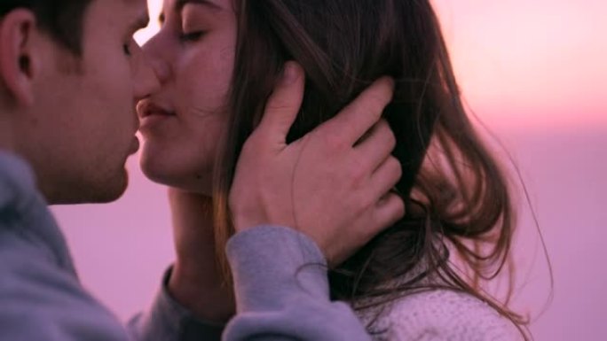 一对夫妇在日落时在海滩上亲吻和拥抱的4k视频片段
