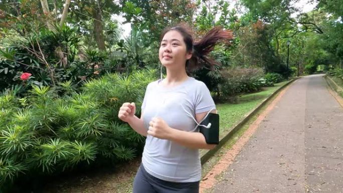 亚洲华裔年轻女子周末早上在公园跑步