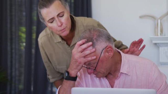 紧张的高加索高级夫妇带着笔记本电脑在家里一起计算财务
