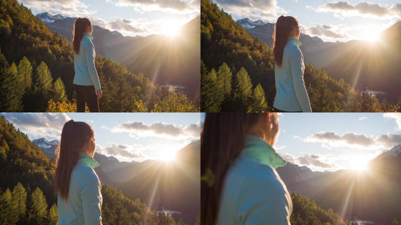 女徒步旅行者站在悬崖边，欣赏山谷湖和周围群山的壮丽景色