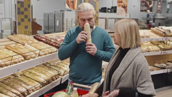 成熟的夫妇在面包店购买新鲜面包