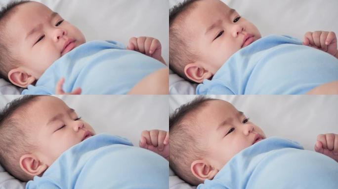 可爱的亚洲女婴6个月大的特写肖像，在家睡觉时穿着温暖的蓝色。东南亚和东亚: 亚洲婴儿概念。
