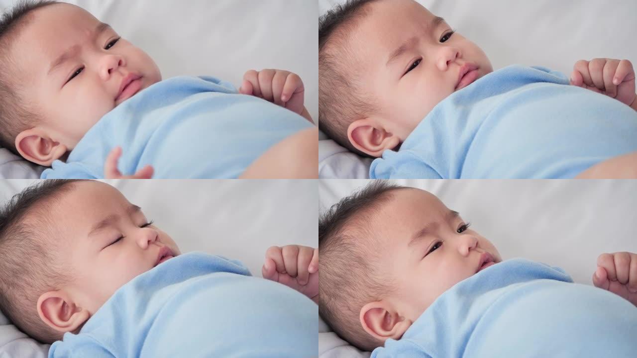 可爱的亚洲女婴6个月大的特写肖像，在家睡觉时穿着温暖的蓝色。东南亚和东亚: 亚洲婴儿概念。