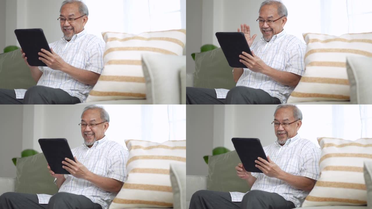 祖父在家中客厅的数字平板电脑上给孙子孙女打视频电话
