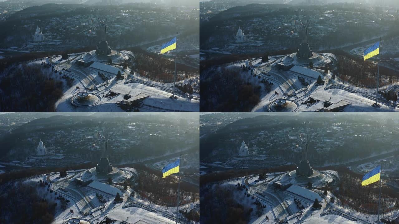 在阳光明媚的寒冷冬日，基辅光荣的独立乌克兰国旗和祖国纪念碑的高角度航拍。