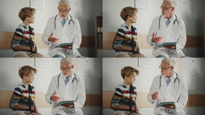友好的中年家庭医生与一个小男孩与手臂支撑和显示测试结果的平板电脑。快乐的医疗保健医生在医院安抚男孩断