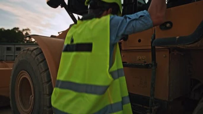 一名无法识别的男性采矿工程师进入矿区大型黄色推土机的慢动作跟踪镜头