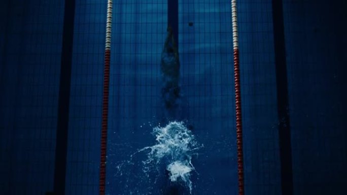 空中俯视图男游泳者跳，潜入游泳池。职业运动员赢得世界冠军。深色戏剧性的饱和颜色，电影光线，艺术自上而