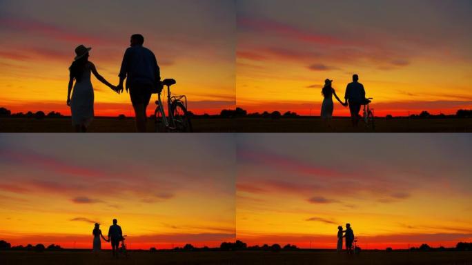 一对成年夫妇牵手亲吻，走向日落和骑自行车的轮廓的静态慢动作镜头