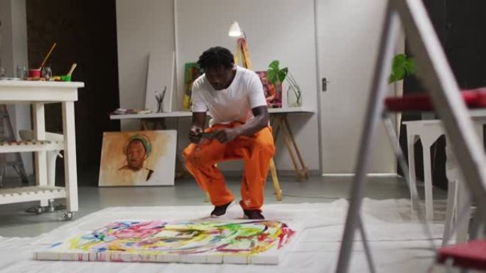 非裔美国男艺术家在art studio用智能手机为自己的画作拍照
