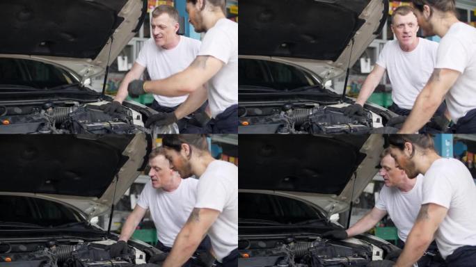 两名机械师在汽车修理厂检查汽车
