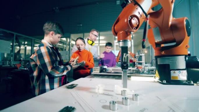 学校tesacher与学童一起研究机器人，设计，技术