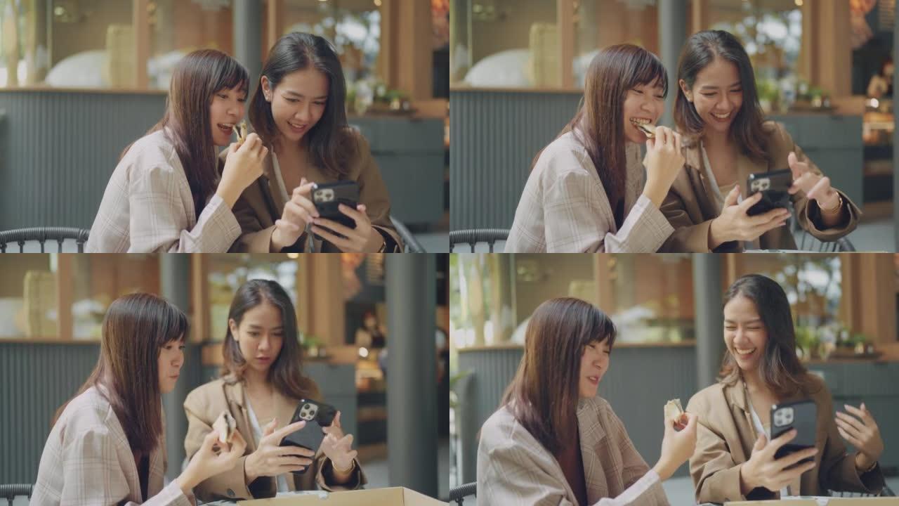 亚洲女性在咖啡馆见面，她的朋友在电话上拍照。