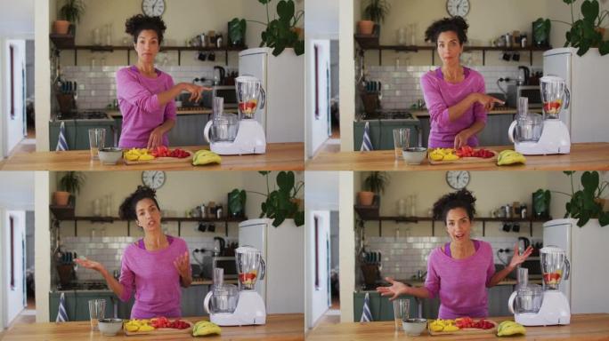 混血女vlogger在家里的厨房里做果汁的肖像
