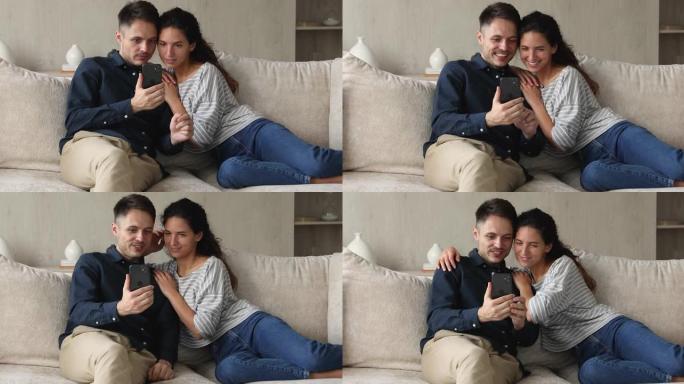 西班牙裔夫妇使用智能手机在沙发上休息