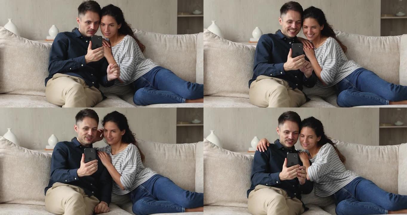 西班牙裔夫妇使用智能手机在沙发上休息