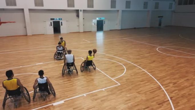 轮椅篮球运动员在练习比赛中投篮的空中俯视图。