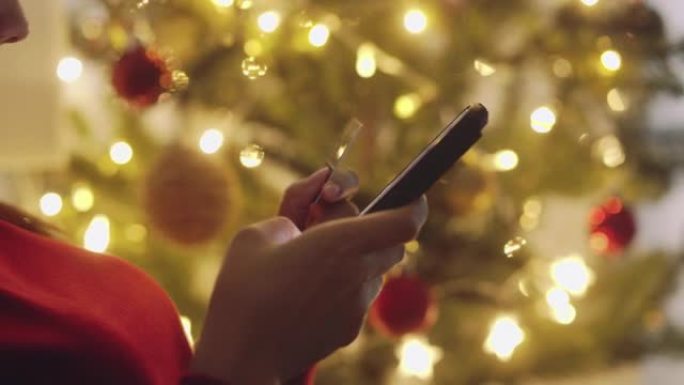 亚洲女孩在圣诞节期间使用智能手机进行在线购物