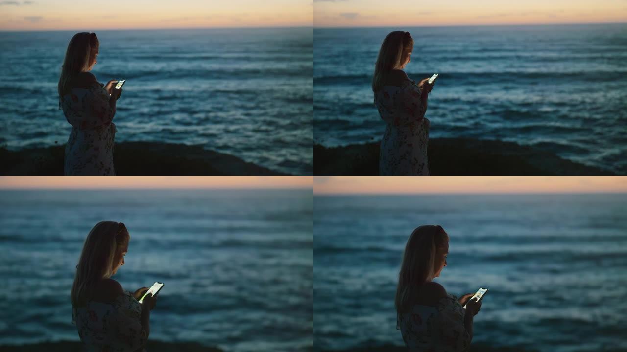 意大利撒丁岛海滩上一个女人看着电话的景色。