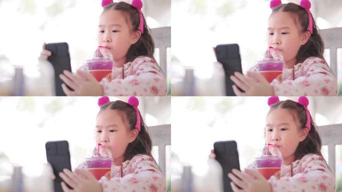 看智能手机的快乐可爱小女孩的CU特写脸