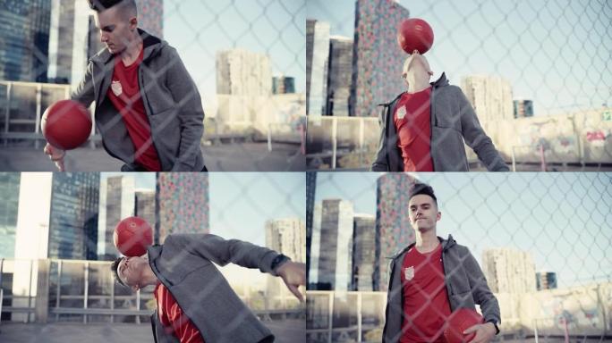 才华横溢的年轻足球运动员用旋转的红球杂耍技巧，将其握在手指和头上。在摩天大楼周围的城市中展示自由式技
