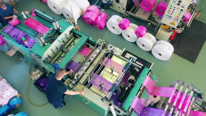 工厂工人监控塑料袋制造机