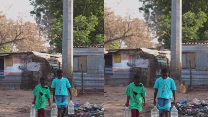 贫穷。不平等。气候变化。两个年轻的非洲黑人儿童携带水供家庭使用的特写镜头。生活条件恶劣，无法获得干净