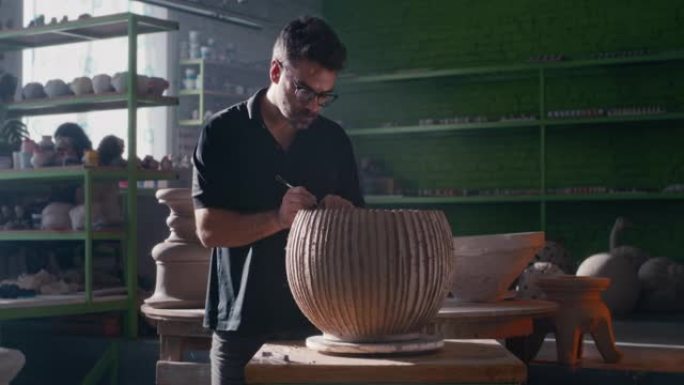 男性陶艺家手工制作条纹粘土器皿