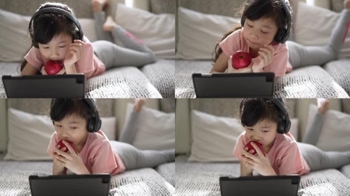 小女孩在家用数字平板电脑在客厅在线学习