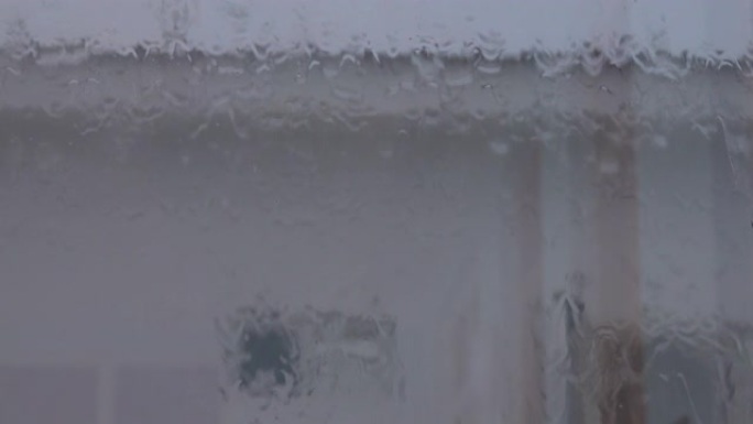 特写: 季风肆虐期间，雨水流从窗户玻璃上流下。