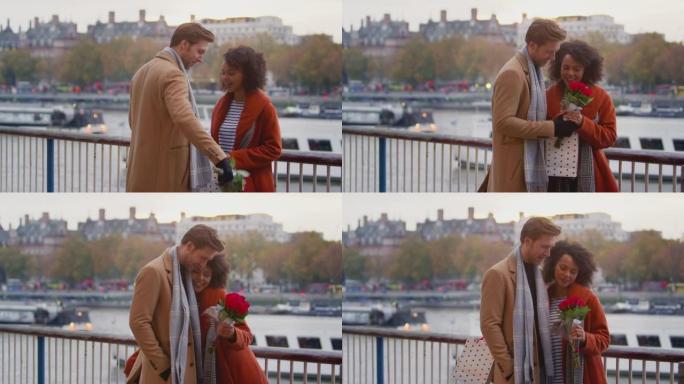 秋天或秋天的夫妇在伦敦泰晤士河上约会，男人给女人礼物和一束鲜花-慢动作拍摄