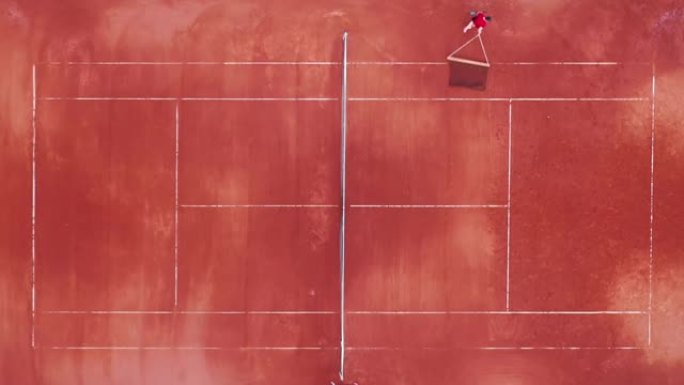网球场，一名男子背着网网，从上方观看