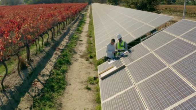 太阳能，无人机和农场工程团队的鸟瞰图检查太阳能电池板，维护或安装。太阳能农场平板电脑上的清洁能源，可