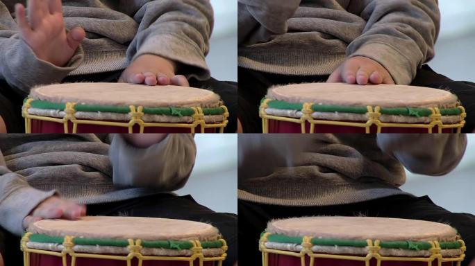 一个孩子的手正在学习演奏康加鼓。特写。
