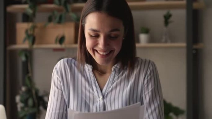 欣喜若狂的千禧一代女商人在办公室阅读纸质信件。
