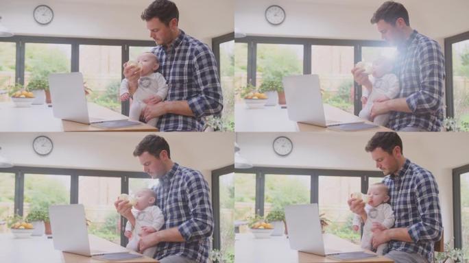 在职父亲在家中使用笔记本电脑，同时用奶瓶喂养膝盖上的婴儿儿子