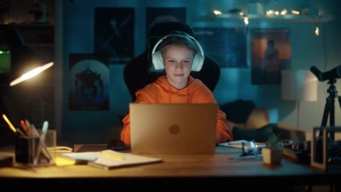 聪明的小男孩把耳机和笔记本电脑放在家里舒适的房间里。快乐少年在线浏览教育研究，与朋友聊天，学习学校作