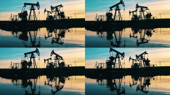 石油和天然气行业概念。日落时在水中反射的抽油地点。原油、天然气、石油价格概念。
