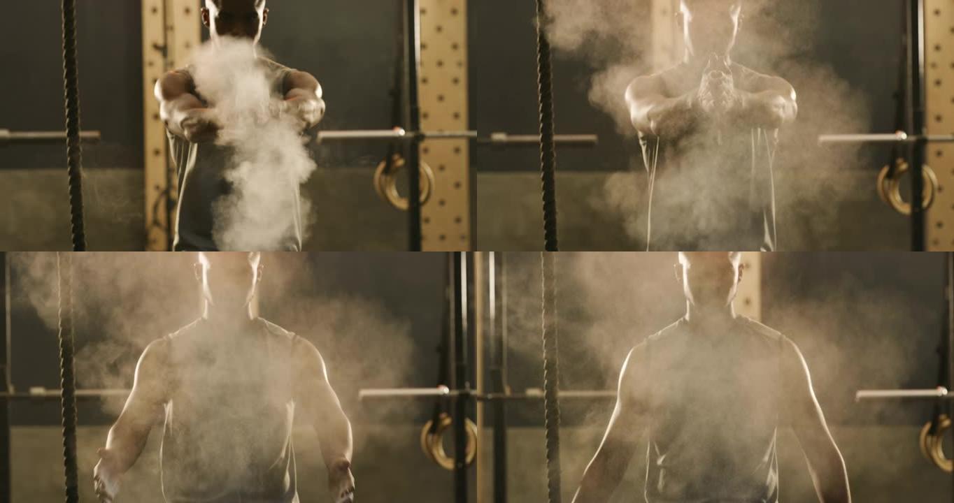4k视频片段，一个肌肉发达的年轻人在健身房用运动粉笔拍打双手