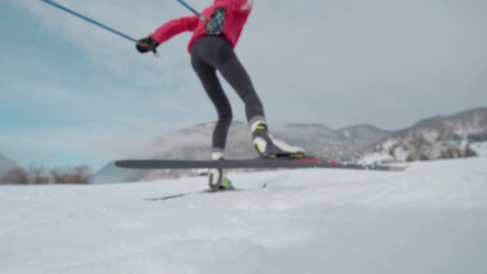 低角度: 在激烈的北欧滑雪训练中，一名女运动员的电影镜头