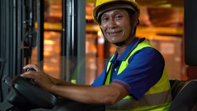 手持肖像: 亚洲男性叉车操作员微笑。